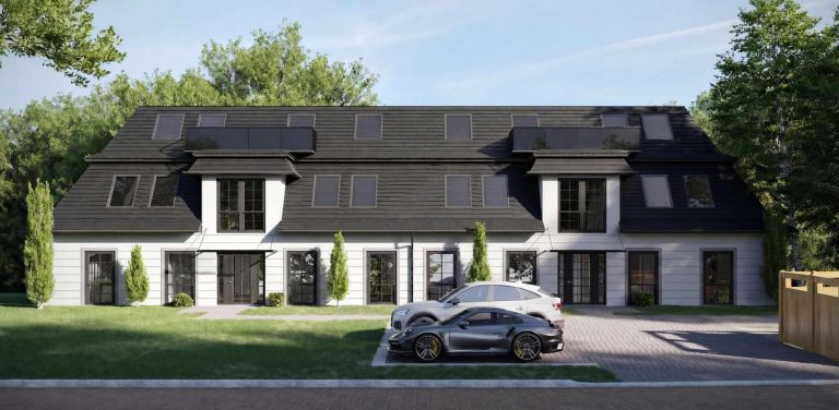 Moderne Doppelhaushälfte mit Terrasse, begrünten Anlagen und einem Parkplatz.
