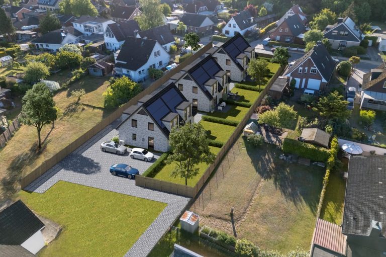 Luftaufnahme von Wohnhäusern mit Solaranlagen und angrenzendem Gartenbereich.