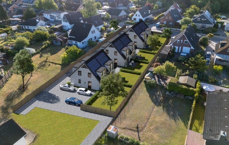 Eine Luftaufnahme von drei modernen Häusern mit Solarzellen und Grünflächen.