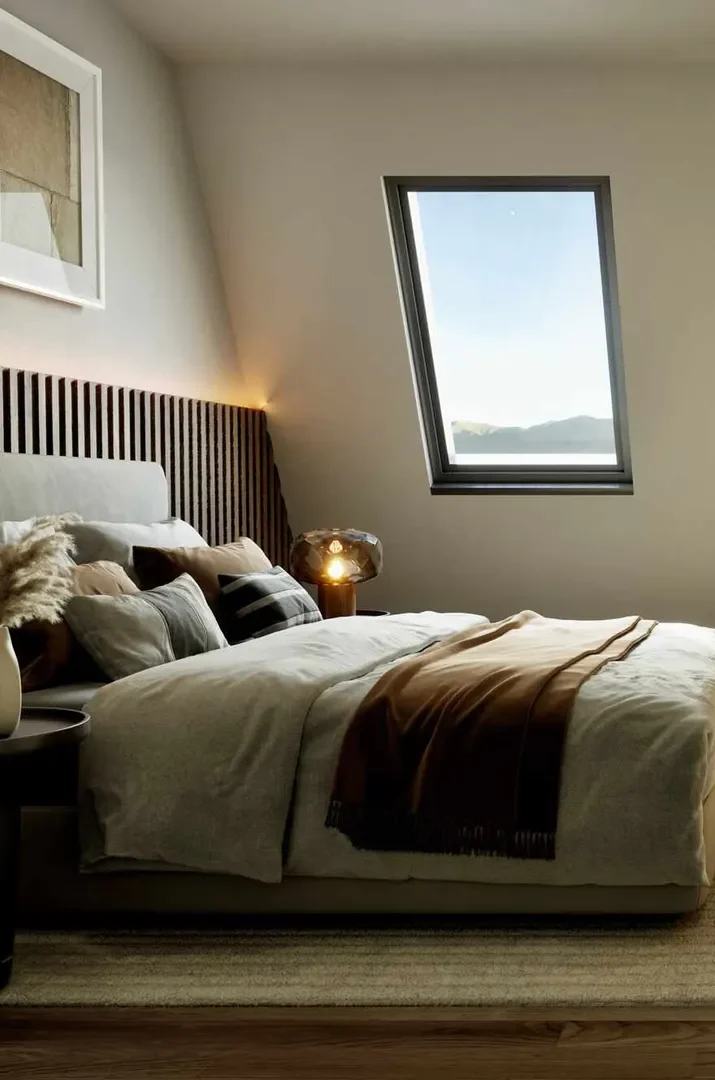 Helles Schlafzimmer mit einem großen Bett, sanften Farben und Blick auf die Natur.